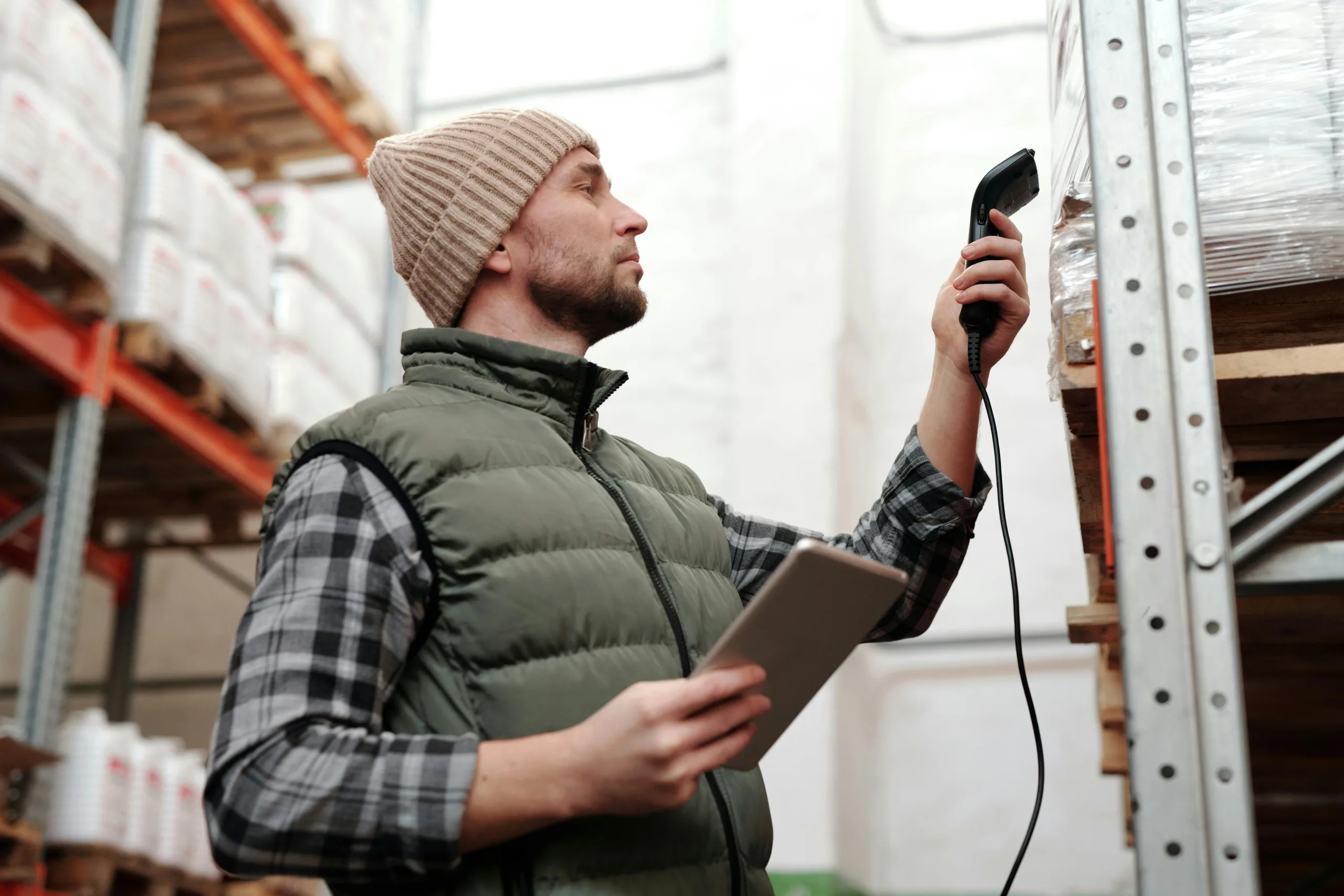 A worker in a warehouse scans inventory.